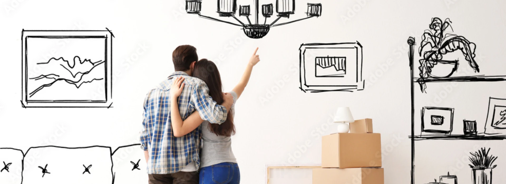 Acquistare casa: 2 ragazzi felici , la ragazza con le braccia alzate dentro uno scatolone in una stanza piena di scatoloni da sballare.  